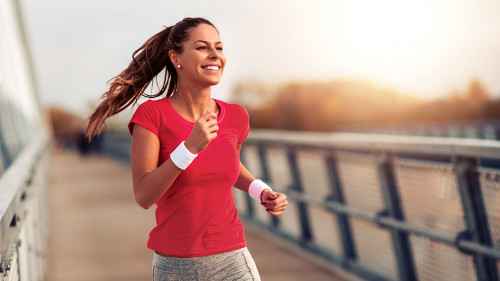 Beautiful woman running over bridge