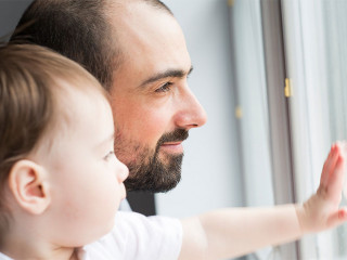 Father and son indoor near the window.