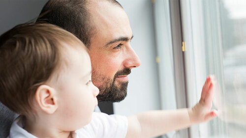 Father and son indoor near the window.