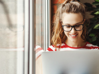 Calm young woman   working on laptop at home