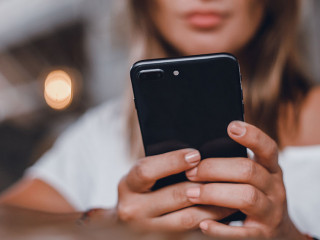 young pretty woman posing in the street with phone, outdoor port