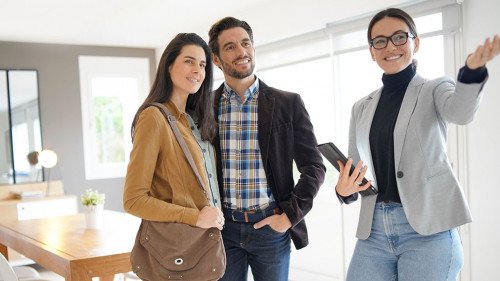 Real estate agent showing modern house to attractive couple