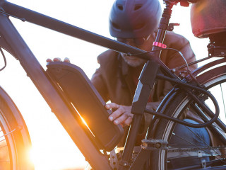 man changing electric bicycle battery