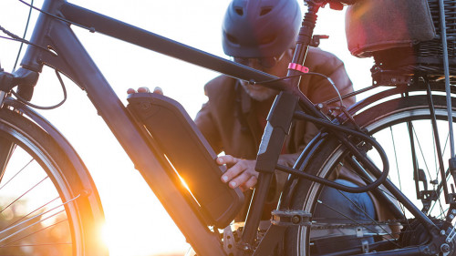 man changing electric bicycle battery