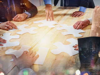 Teamwork of partners connect puzzle pieces as integration and startup