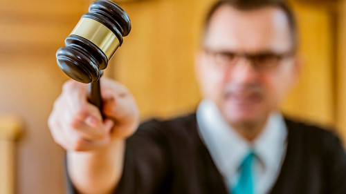 portrait judge man in courtroom holding judge gavel