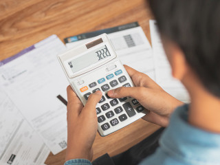 Top view man sitting on the floor stressed and confused by calcu
