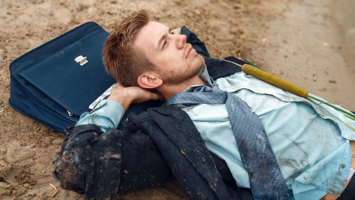 Office worker resting on the beach, desert island