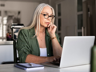 Worried senior woman using laptop