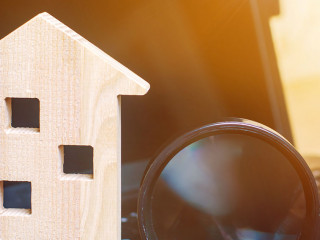 House and magnifying glass on the keyboard. The concept of housing search in the the Internet. Buy an apartment for sale online. House rent. Sell property. Affordable housing. Search for a hotel