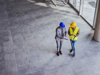 Top view of architect holding tablet and talking with constructi