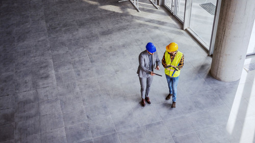 Top view of architect holding tablet and talking with constructi