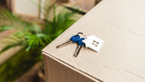 close-up view of keys from new house on cardboard box during rel