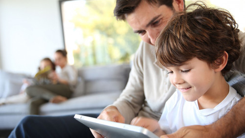 Father and son playing with digital tablet