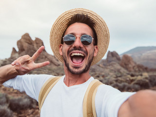 Handsome hiker taking a selfie hiking a mountain using his smart