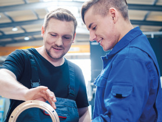 Master discussing a workpiece with his apprentice or trainee