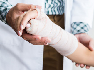 Close-up of man doctor of checking splint the arm of female pati