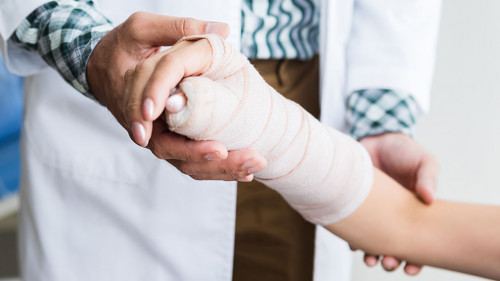 Close-up of man doctor of checking splint the arm of female pati