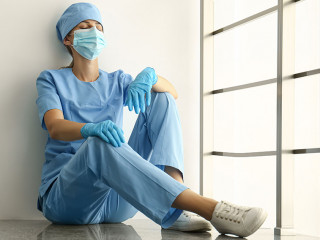 Exhausted doctor indoors. Stress of health care workers during C