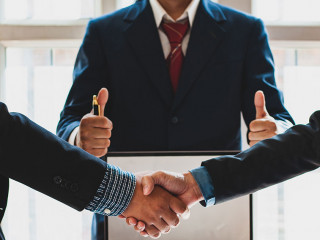 Business people shake hands while negotiating a business deal. C