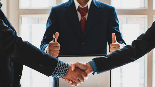 Business people shake hands while negotiating a business deal. C