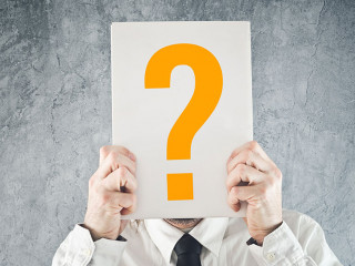 Businessman holding paper with printed question mark