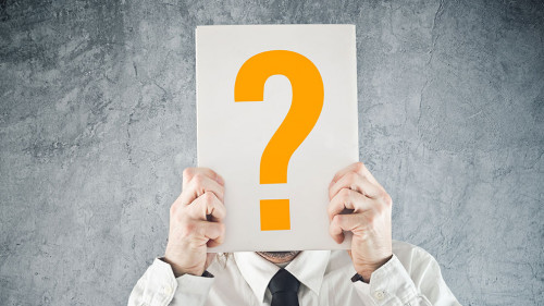 Businessman holding paper with printed question mark