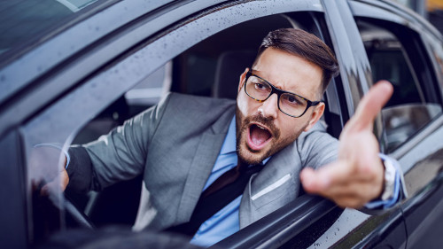 A sharp dressed man finding himself caught in a rush hour and sl