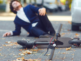 Accident with an electric scooter. A man fell from a scooter on a city street.