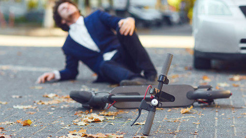 Accident with an electric scooter. A man fell from a scooter on a city street.