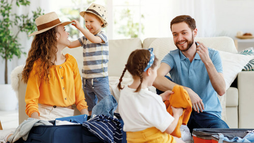 Playful family packing for holiday at home
