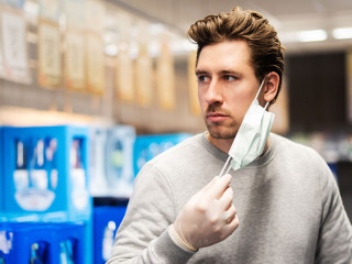 Coronavirus, Mann schützt sich im Laden mit Atemmaske und Hands