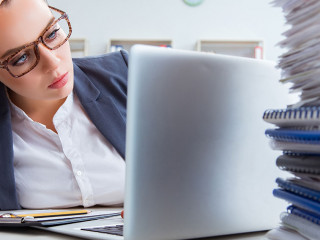 Tired businesswoman with paperwork workload