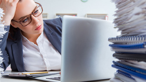 Tired businesswoman with paperwork workload