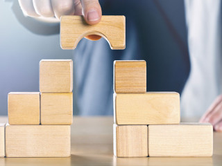 Business man bridging the gap between two towers or parties made