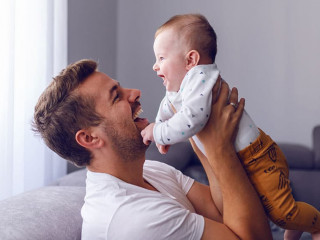 Playful handsome caucasian young dad lifting his loving 6 months