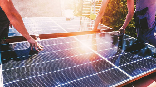 Workers assemble energy system with solar panel for electricity and hot water