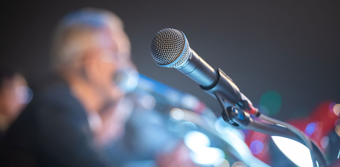 Business people talking on seminar panel with microphone