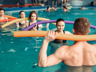 Instructor and group on workout in swimming pool