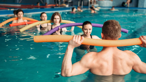 Instructor and group on workout in swimming pool