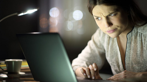 Suspicious woman checking laptop content in the night