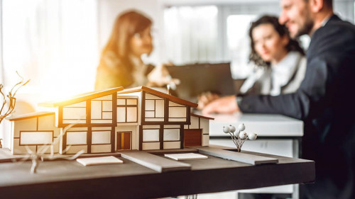 Close up image of house model with group business people on blur