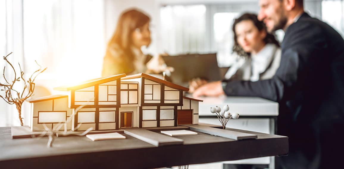Close up image of house model with group business people on blur