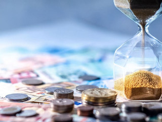 Hourglass and currency on table, Time Investment concept