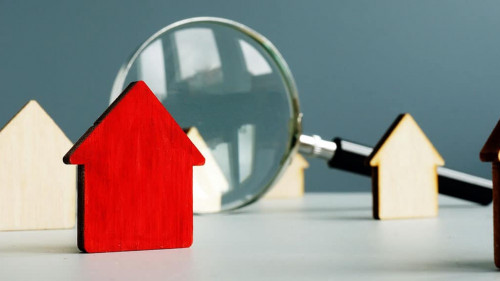 Home worth and property value concept. Magnifying glass and model of house.