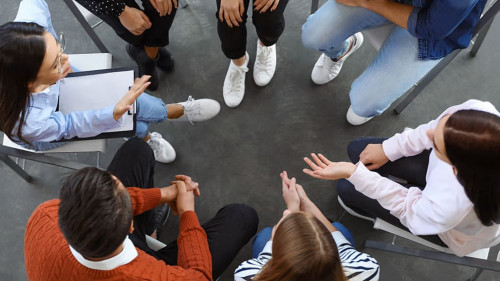 Psychotherapist working with patients in group therapy session,