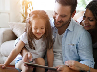Family holding a tablet and looking at it