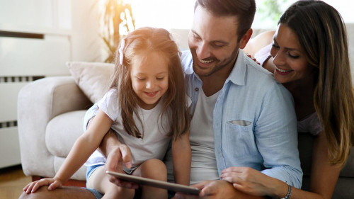 Family holding a tablet and looking at it