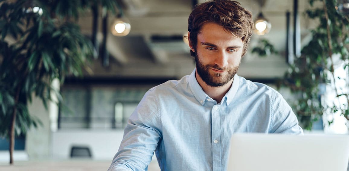Businessman in shirt working on his laptop in an office