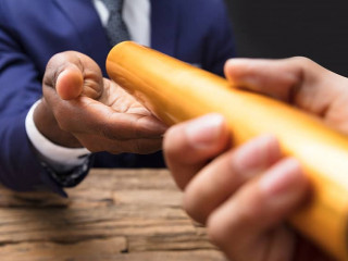 Businessman Passing Baton To His Partner